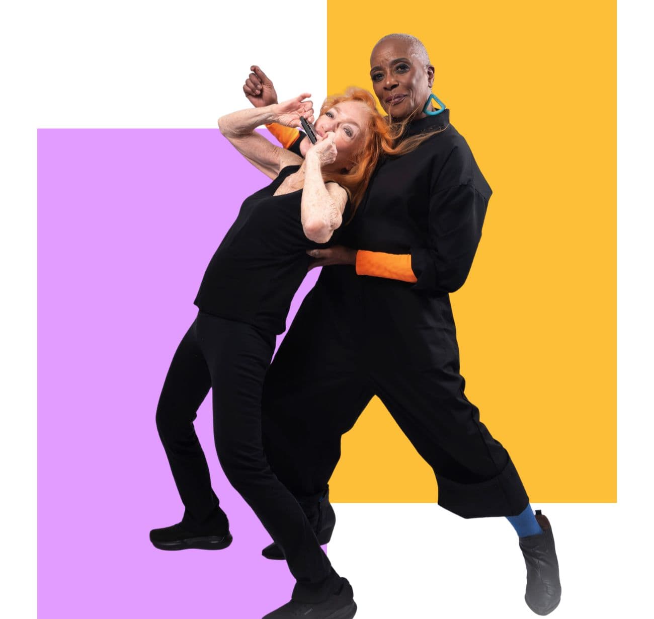 Two dancers dance cheek to cheek in front of lilac and yellow blocks.