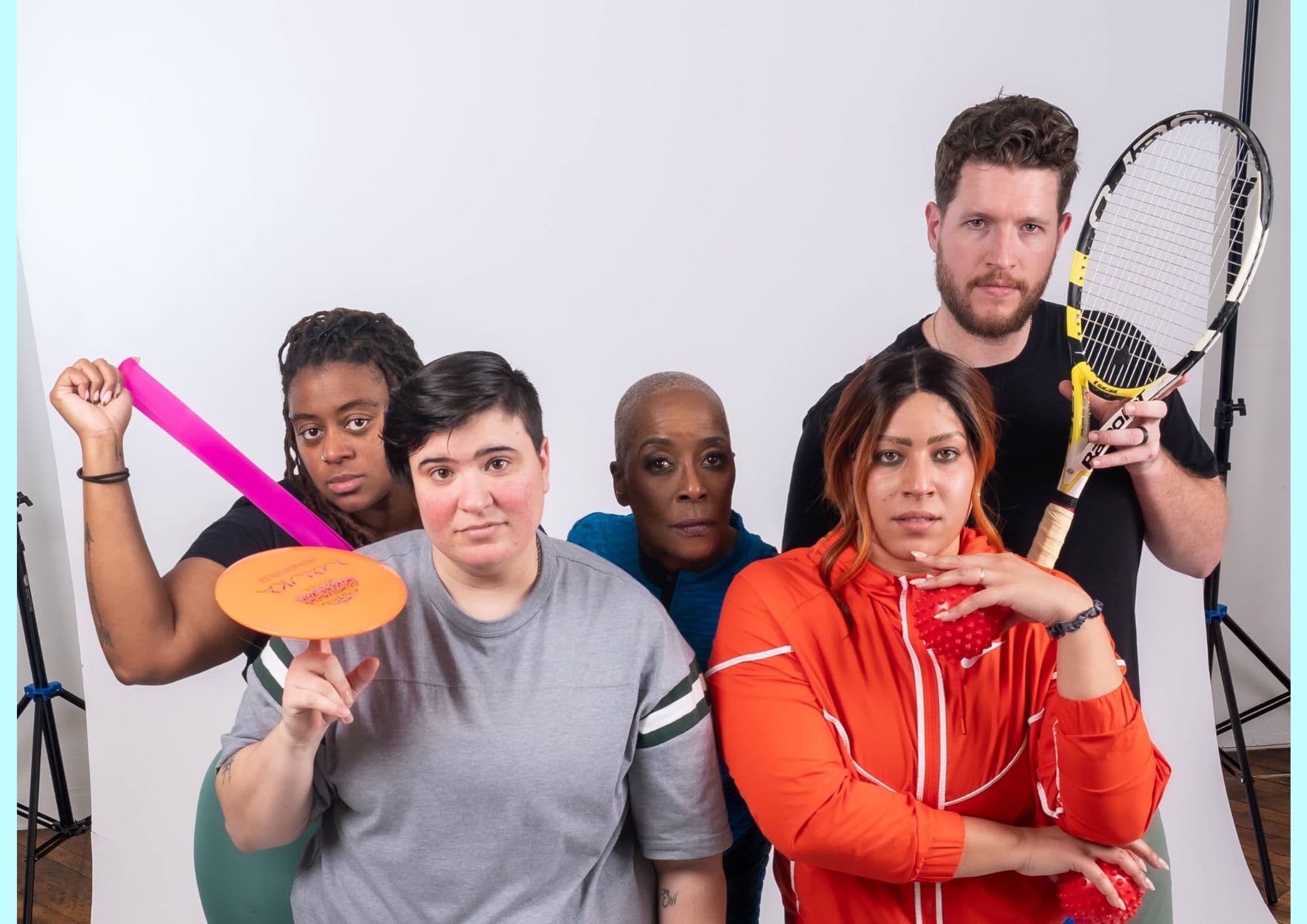 A group of workshop participants pose with a tennis racket, a frisbee and a resistance band.