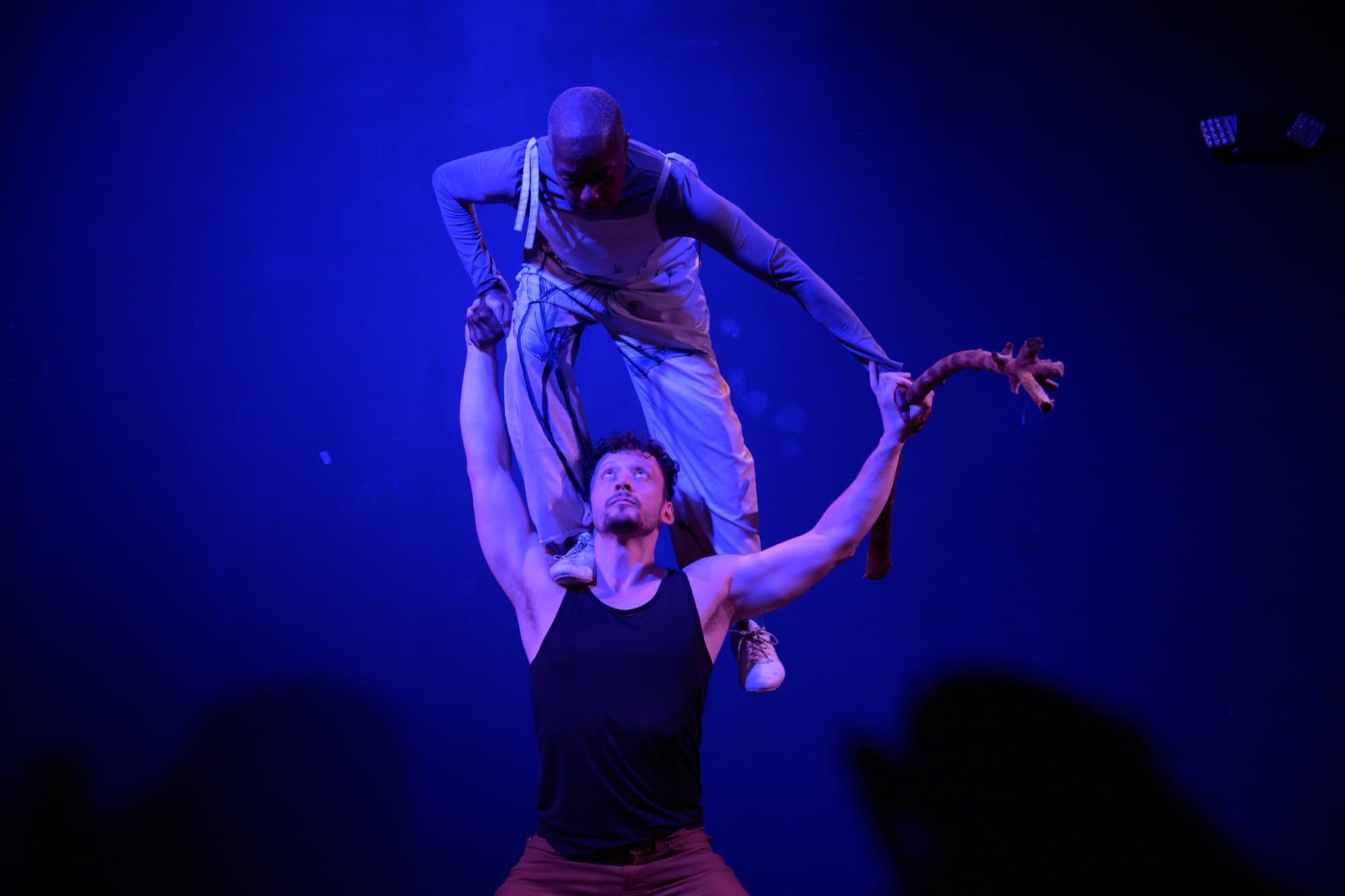 Ben lifts Rhonda overhead against a deep blue stage.